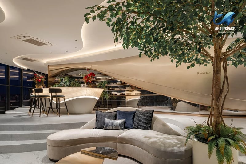 Luxurious lounge area with a curved sofa, modern bar, and lush greenery