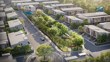 Aerial view of a modern townhouse development with a central green park and winding roads.