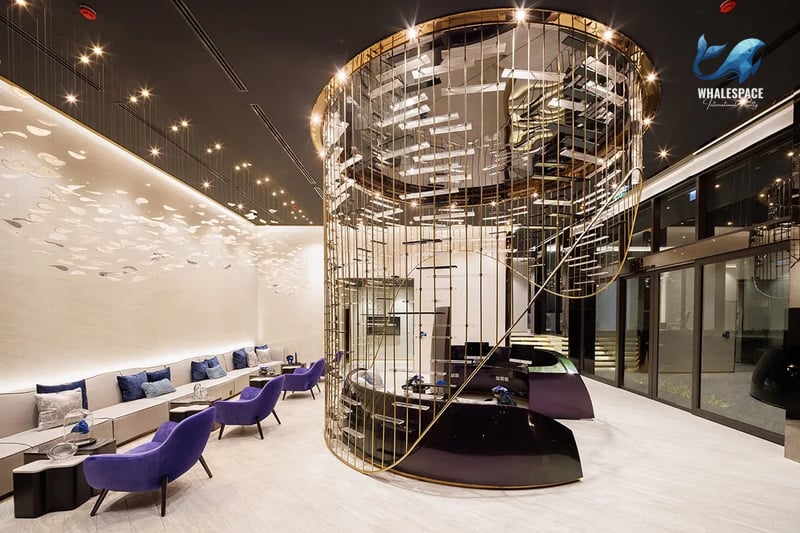 Luxurious lobby area featuring a striking gold decorative cylinder and elegant modern seating in shades of purple and grey