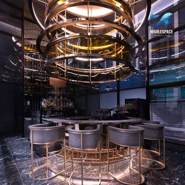 Elegant circular bar area with plush seating and dramatic pendant lighting.