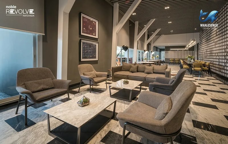 Expansive modern lounge with diverse seating options, marble coffee tables, and striking patterned flooring.