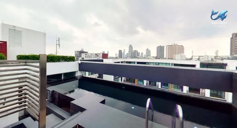 Infinity swimming pool on the rooftop, showcasing breathtaking city skyline views in the distance.