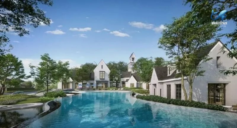 Stunning infinity pool reflecting the blue sky, set amidst a cluster of modern European-style houses with pitched roofs.