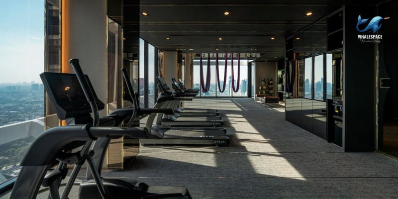 Well-equipped fitness center with treadmills and yoga hammocks overlooking the city