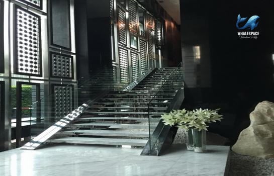 Elegant lobby with a striking modern staircase and artistic floral arrangement