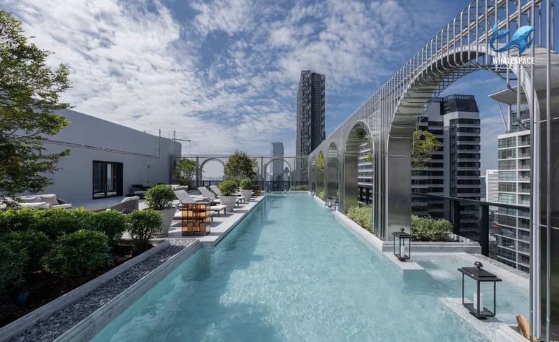 Stunning rooftop infinity pool with comfortable lounge seating and breathtaking city vistas.