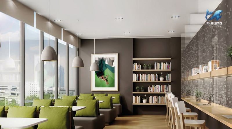 Relaxing resident lounge area with cozy seating in green, a dedicated reading nook with bookshelves, and large windows.