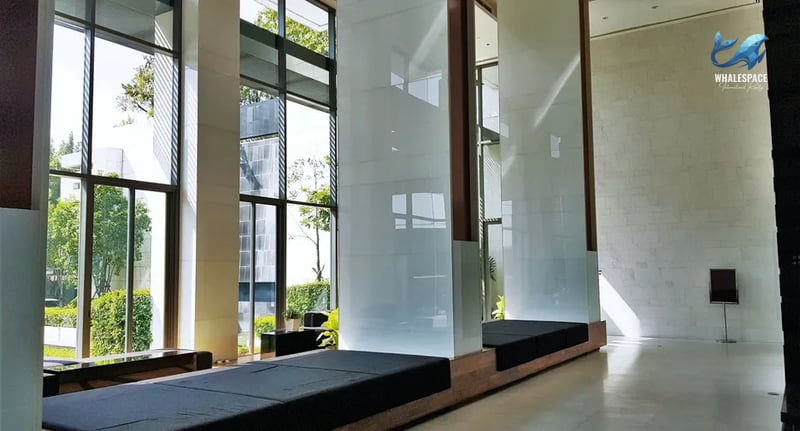Grand lobby with high ceilings, floor-to-ceiling windows, and modern seating