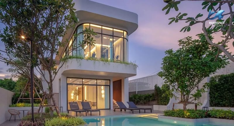 Inviting swimming pool with chaise lounges and a modern building in the background at dusk
