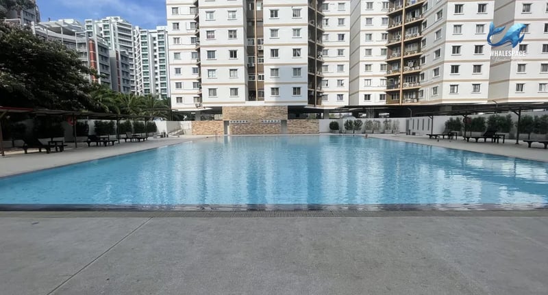 Expansive swimming pool with clear blue water and surrounding lounge chairs