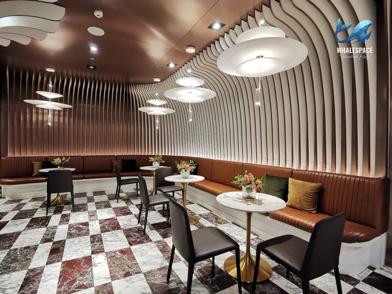 Stylish lounge with curved seating, round tables, and unique pendant lighting