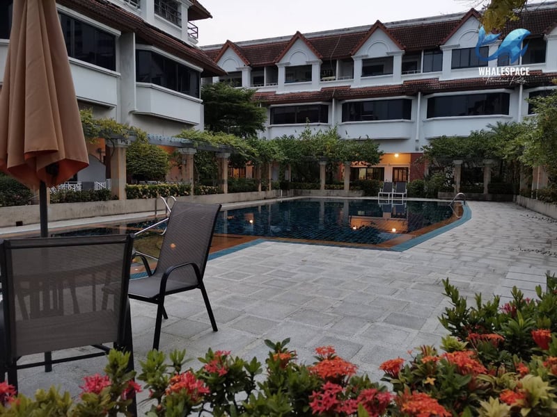Relaxing poolside seating area with tables and chairs, overlooking the shimmering water
