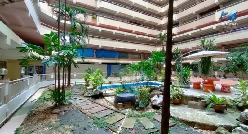 Courtyard garden featuring a serene pond, stepping pathways, and ample plant life.