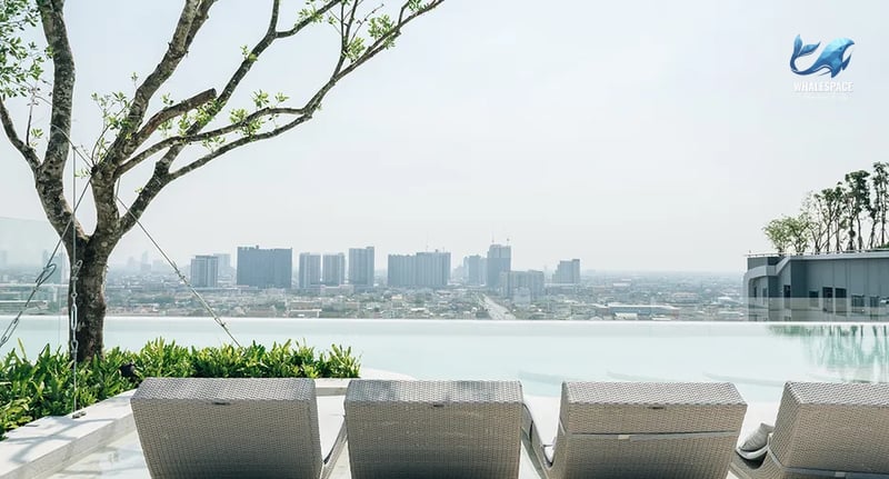 Infinity swimming pool with city skyline views and ample lounge seating.
