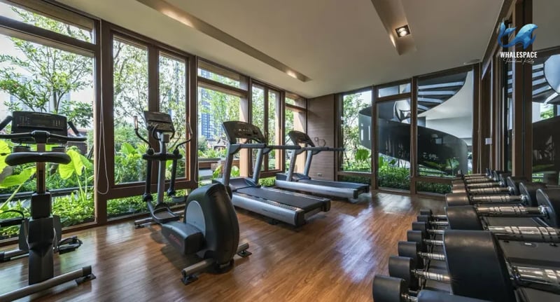 State-of-the-art fitness center equipped with treadmills, elliptical machines, and a comprehensive dumbbell rack.