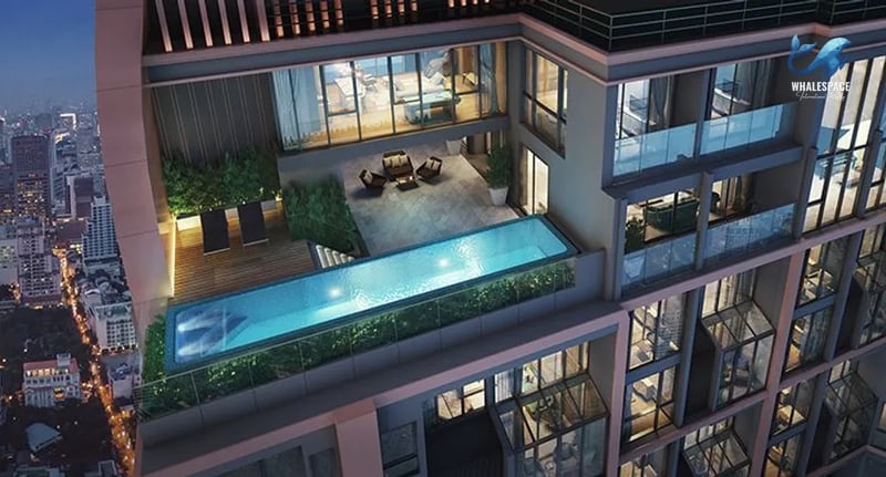 High-rise infinity pool with clear blue water, sun loungers, and an outdoor terrace overlooking the city.