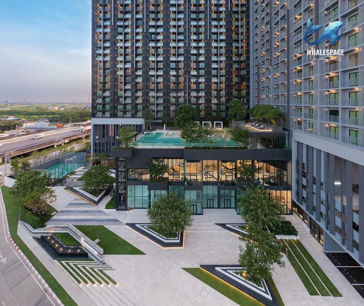 Modern high-rise condominium exterior with geometric landscaping and a rooftop pool.