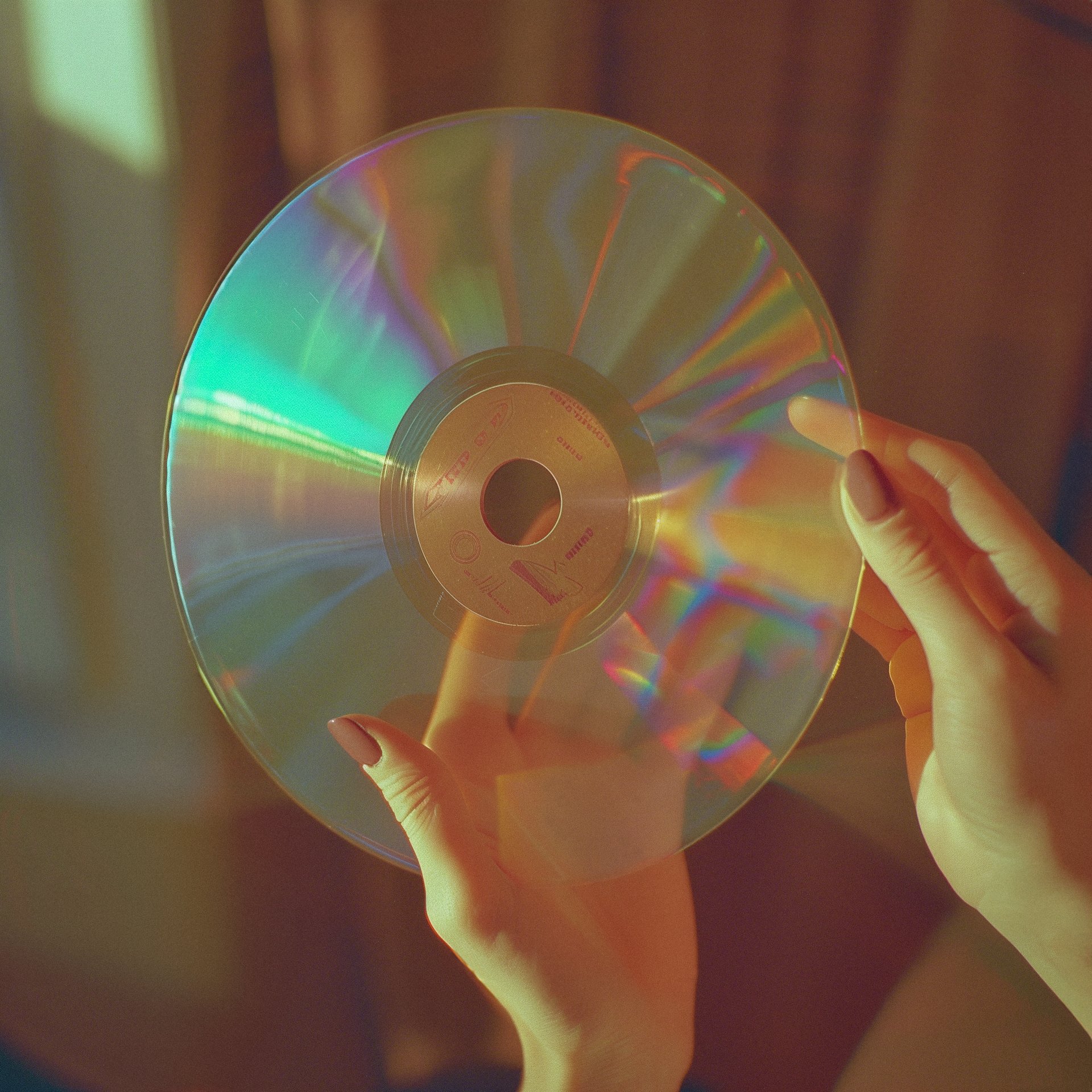 A hand holding a CD