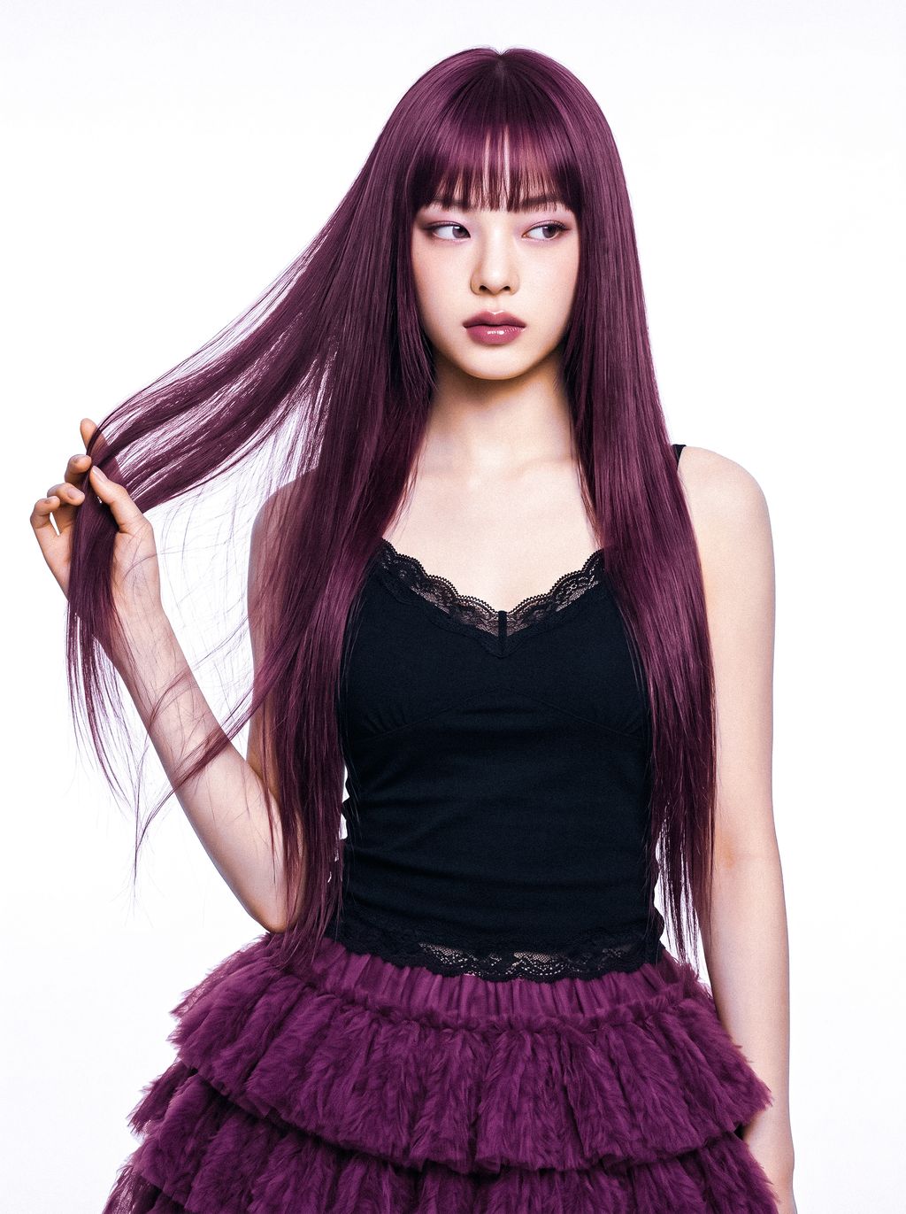 Young woman with long purple hair in black top and purple ruffled skirt, looking sideways.