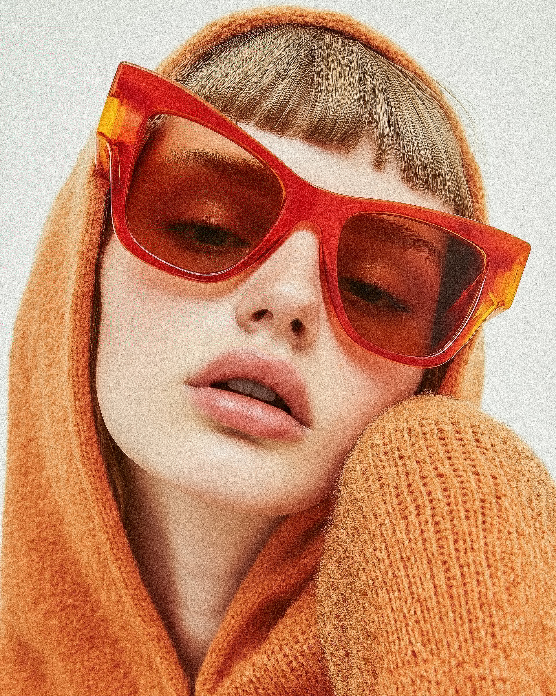 Woman in orange with tilted sunglasses
