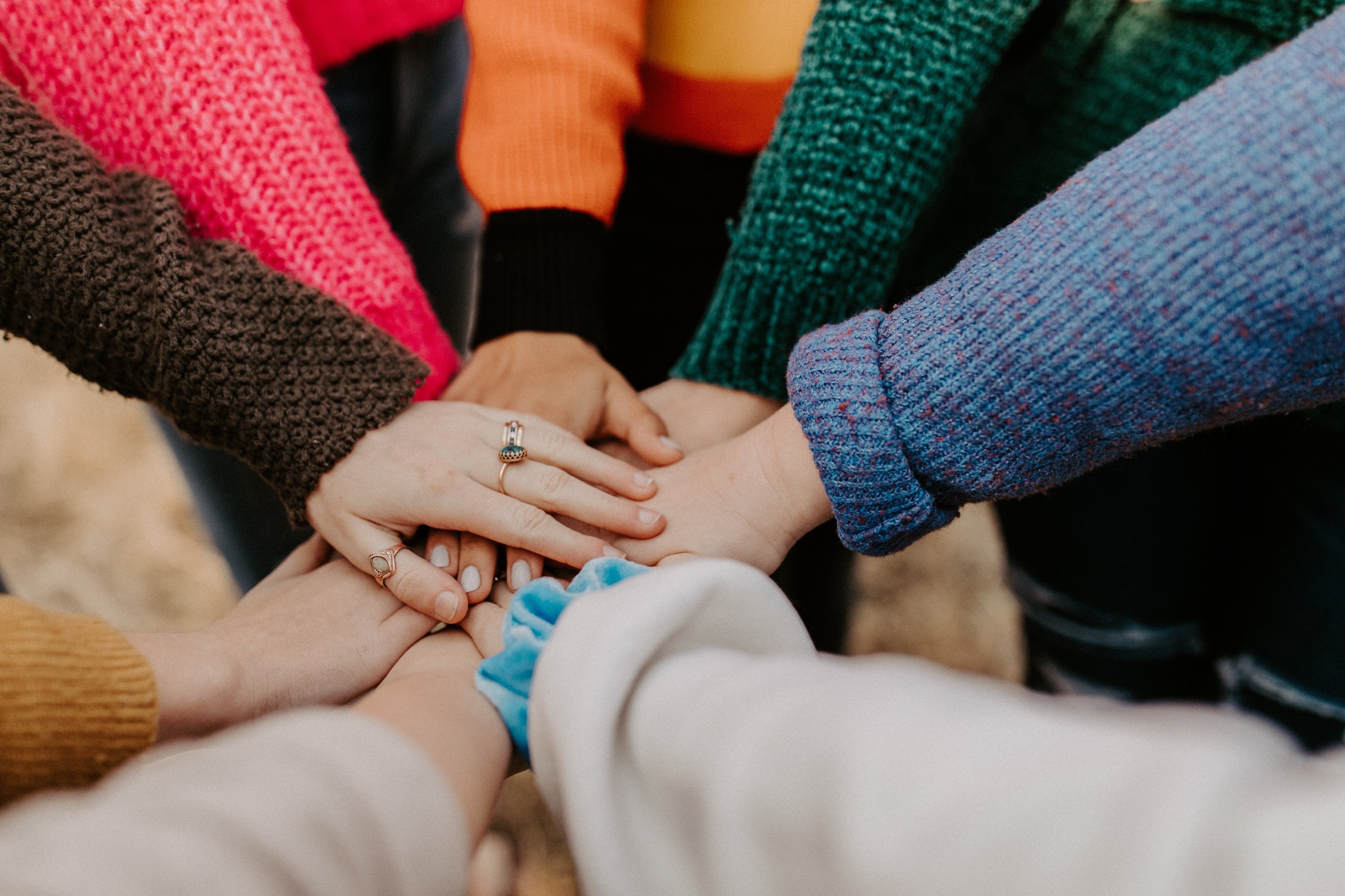 a group of people's hands, placed one on top of the other