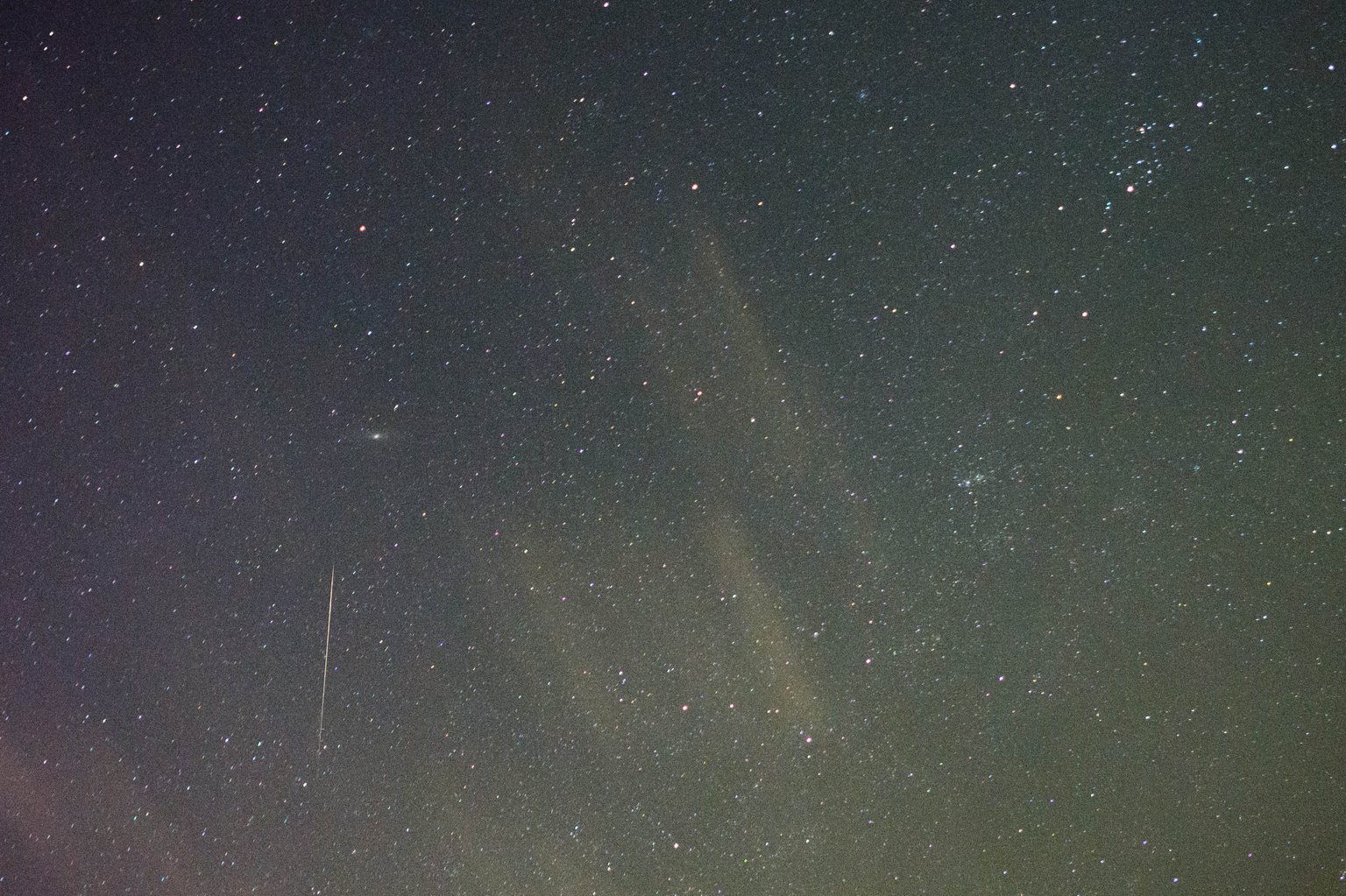 Tenká stopa Orionidy na hvězdném pozadí poblíž galaxie v Andromedě.