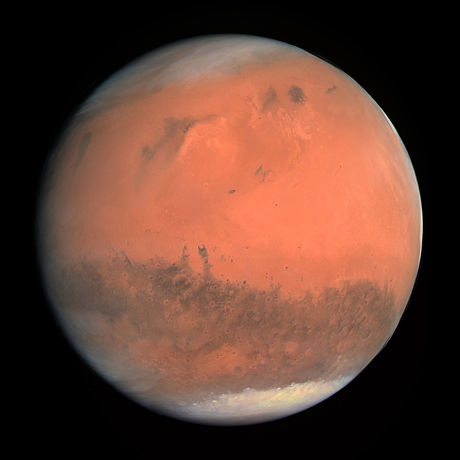 Mars s tmavými oblastmi a světlou polární čepičkou na snímku kamery OSIRIS.