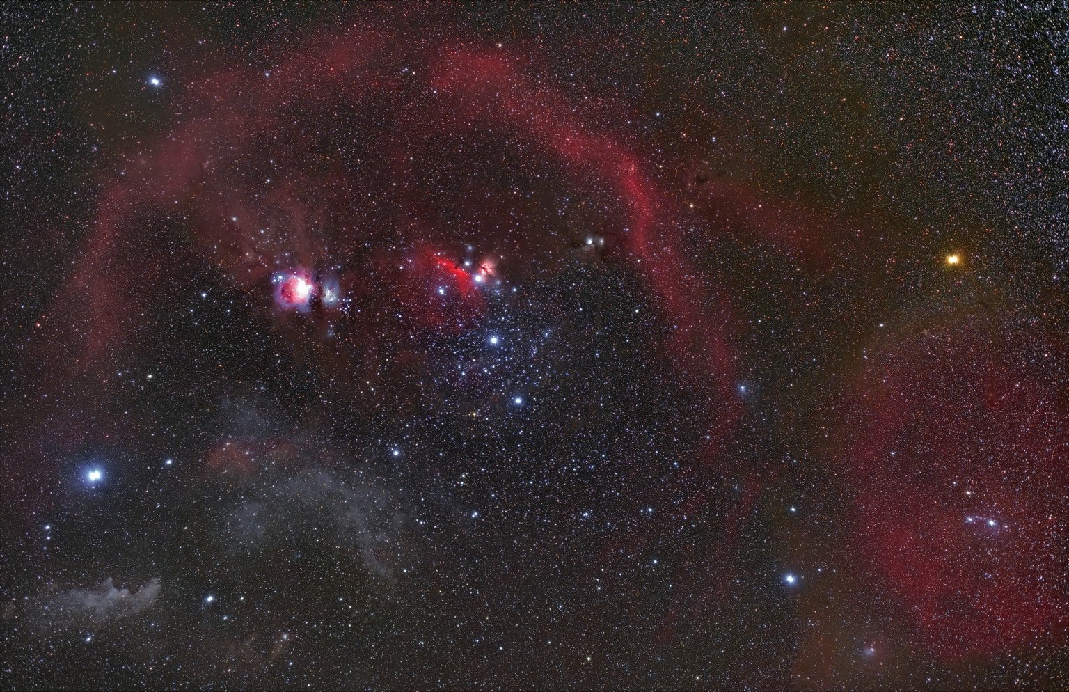 Širokoúhlá fotografie Orionu s mlhovinou M42 a rozsáhlými oblouky plynu a prachu