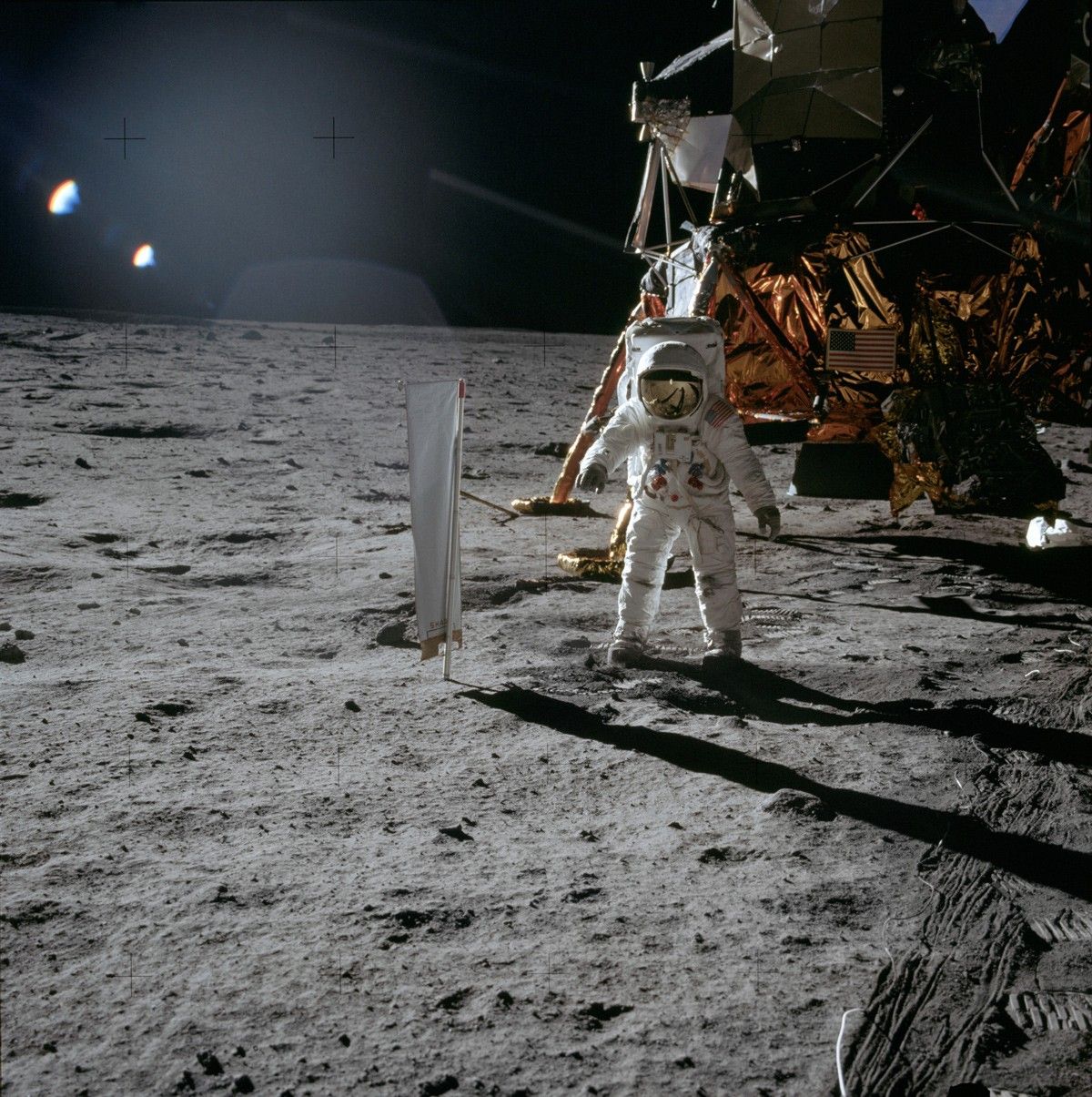 Buzz Aldrin ve skafandru na Měsíci, v pozadí lunární modul Apolla 11