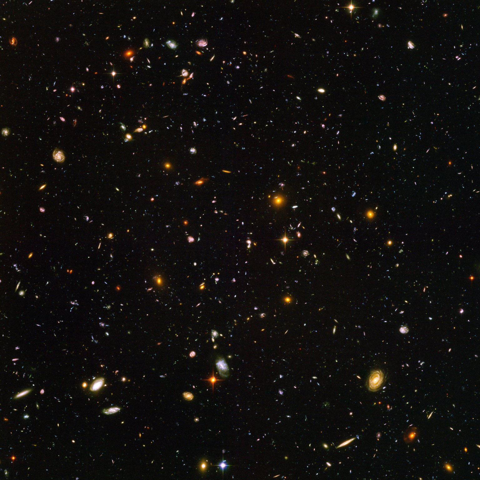 Hubble Ultra Deep Field s tisíci malých galaxií různých tvarů a barev.