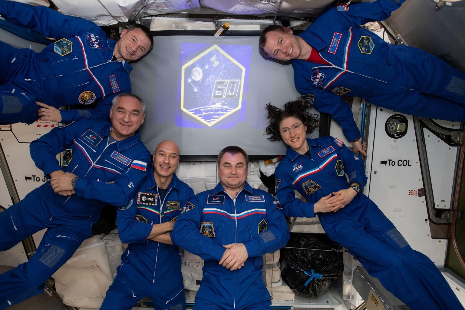 Šestičlenná posádka Expedice 60 v různých polohách uvnitř modulu Harmony na ISS.