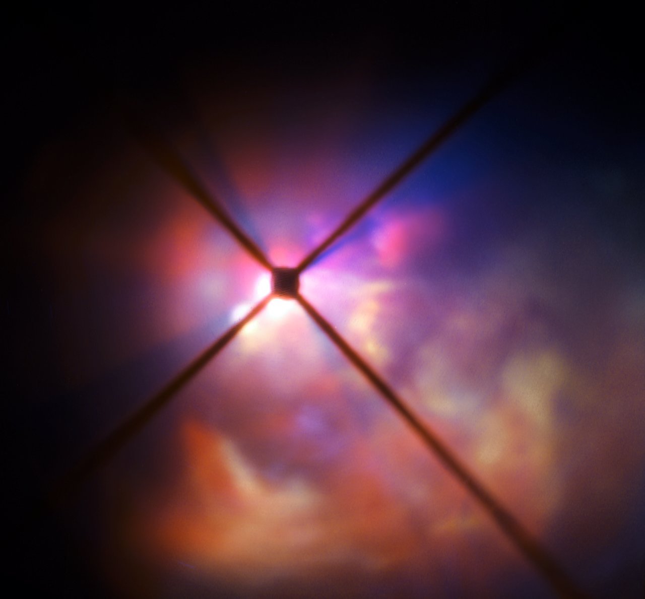 Prachové okolí VY Canis Majoris s centrální clonou a tmavým křížem přístroje