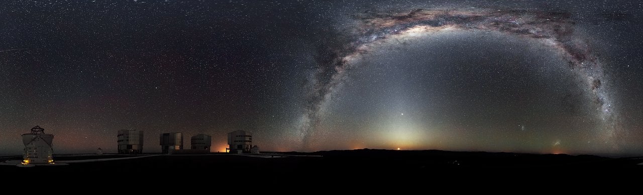 Oblouk Mléčné dráhy nad kopulemi observatoře Paranal v Chile