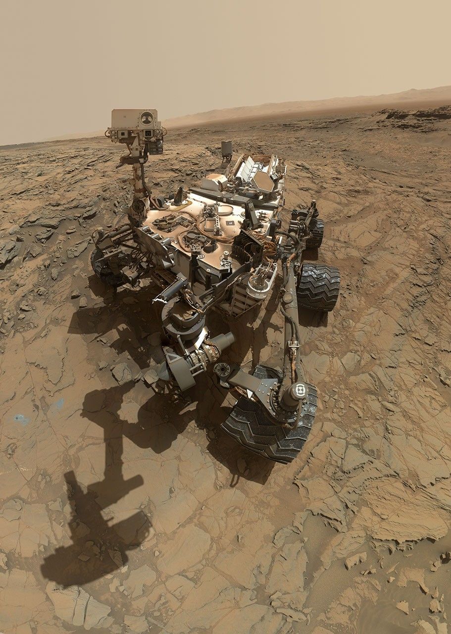 Rover Curiosity na skalnatém povrchu u lokality Big Sky v kráteru Gale.