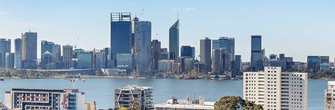Aerial view of a modern cityscape featuring sleek buildings and lush green spaces.
