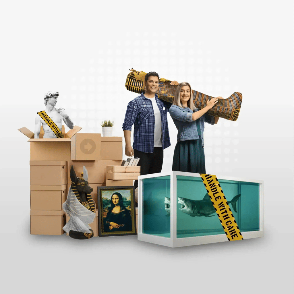 A smiling couple stand among moving boxes, carrying an Egyptian sarcophagus. Nearby, Yello Truck Hire boxes hold famous art pieces, a statue, a shark in a tank, and an Anubis figure—all marked with HANDLE WITH CARE tape.