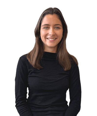 Charlotte Bell, a young woman with long brown hair wearing a black polo-neck jumper, smiles at the camera against a plain white background.