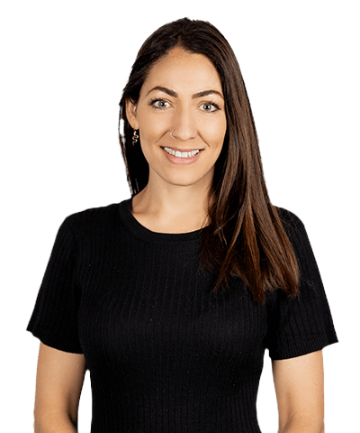 A woman with long brown hair, wearing a black short-sleeve ribbed top, smiling and facing the camera against a plain white background.