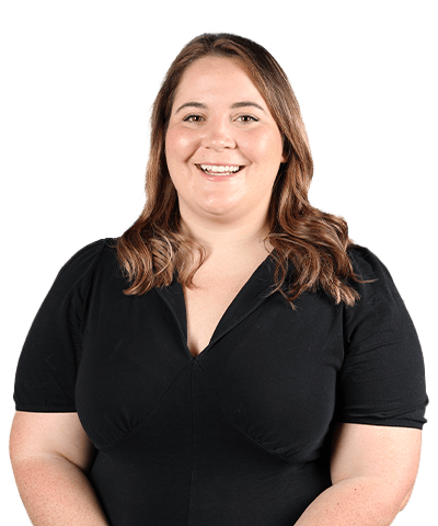 A woman with light brown hair wearing a black dress smiles at the camera against a plain light background.
