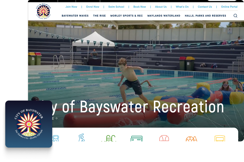 A child runs across a floating inflatable assault course in an outdoor swimming pool at a leisure centre, with empty poolside chairs and a fence in the background—perfect for sharing on Paid Socials.