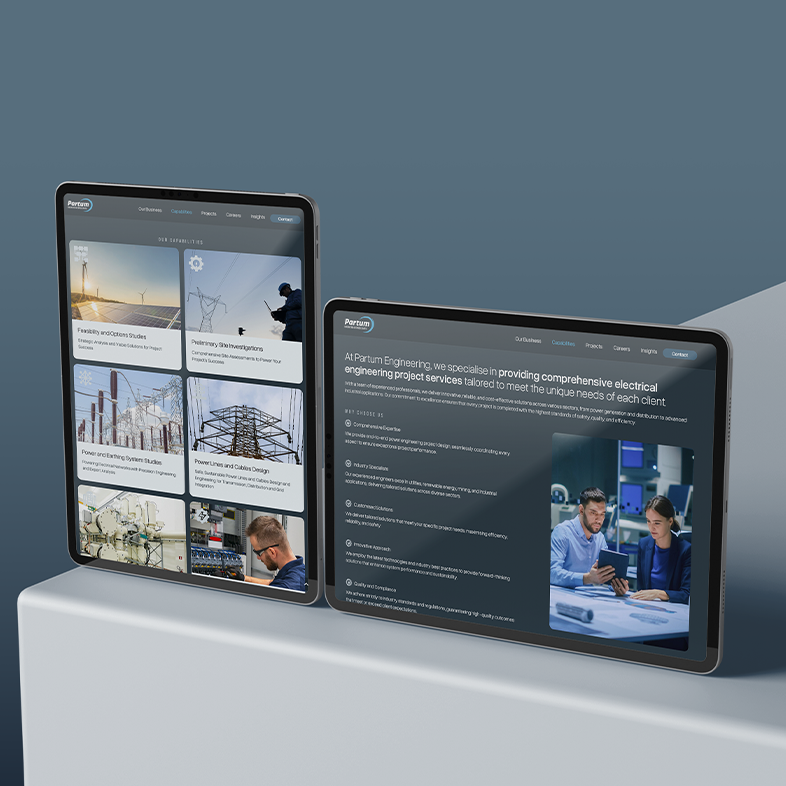Two tablets displaying the Partum Engineering website—one with project listings and images, the other featuring detailed info and a photo of two people discussing work in an office—are propped up on a grey surface.