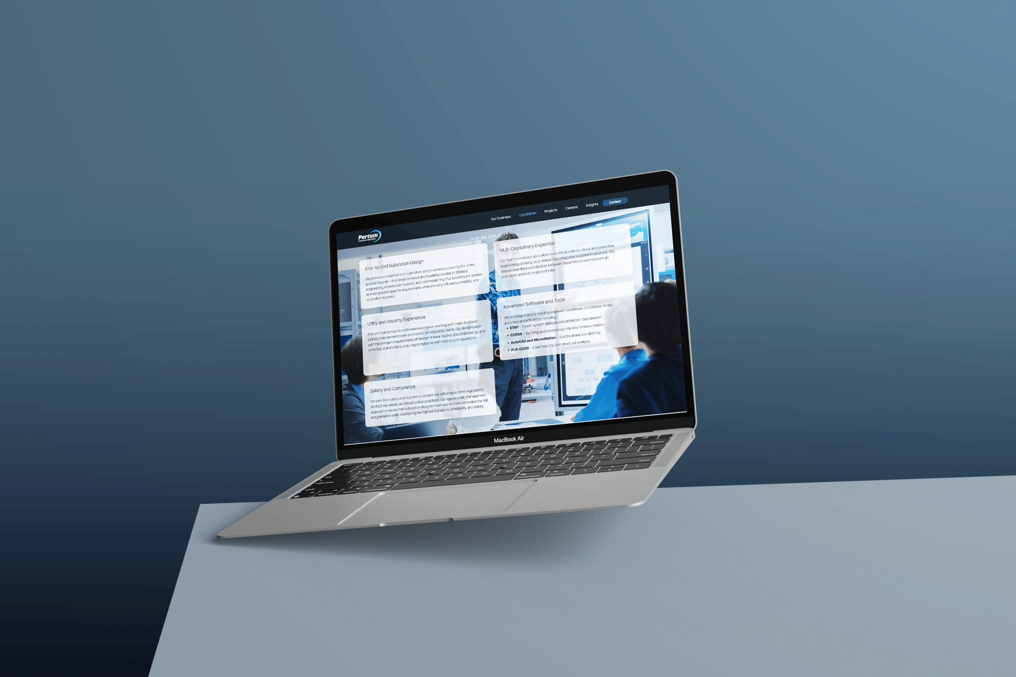 A MacBook laptop is displayed on a light blue surface with a blue gradient background. The screen shows Partum Engineering’s website, featuring multiple white chat bubbles and blurred figures in the background.