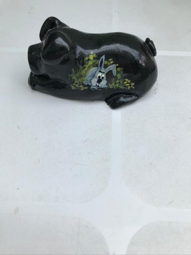 Black painted pottery pig measuring 2 inches in length