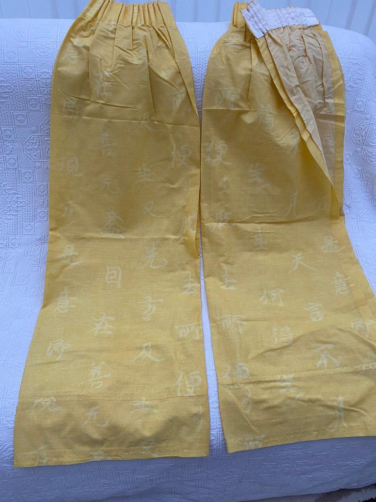 YELLOW CURTAINS WITH TIE BACKS.
