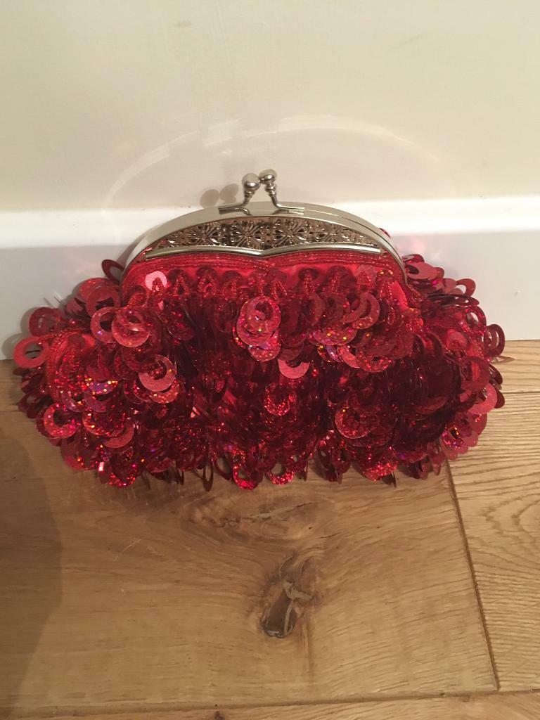 Stunning brand new red sequinned handbag with silver coloured snap fastening and chain.