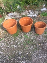 Three plastic terracotta colour garden pots