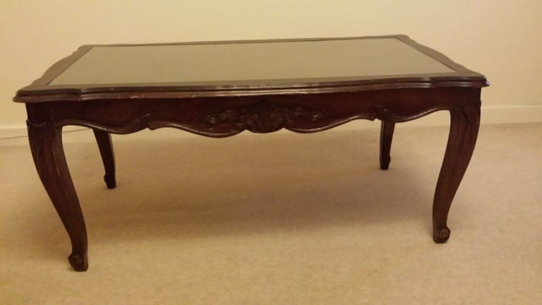 Solid wood coffee table with glass top.