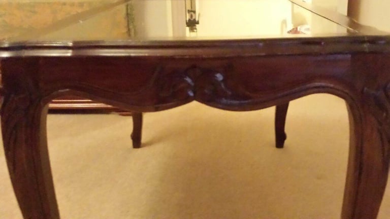 Solid wood coffee table with glass top.