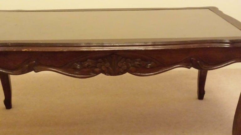 Solid wood coffee table with glass top.