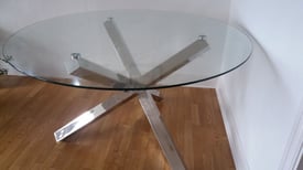 Large round glass dining table with chrome metal legs